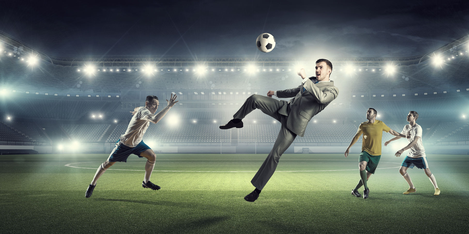 57522757 - young businessman in suit playing football at stadium